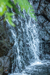 Fresh mountain water cascades down a dark rock face © wundermann