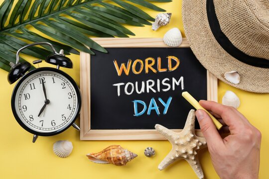 World Tourism Day sign with a clock and shells. Vacation planning concept.