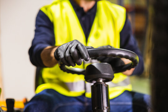 Worker operating forklift in warehouse or lumberyard