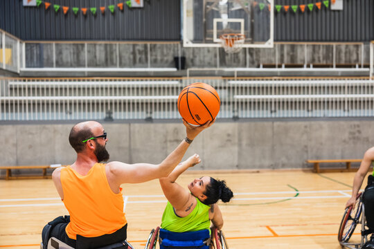 Athletes playing wheelchair basketball game on court