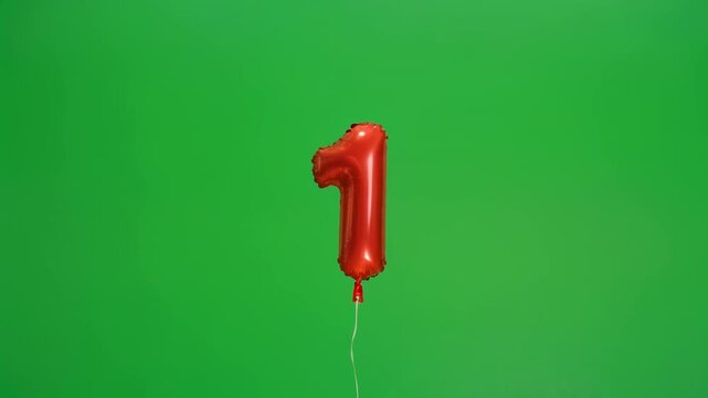 Red Number One Balloon Floating Against Green Screen With Subtle Camera Pan