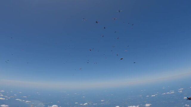 More than 100 skydivers together in a large formation.