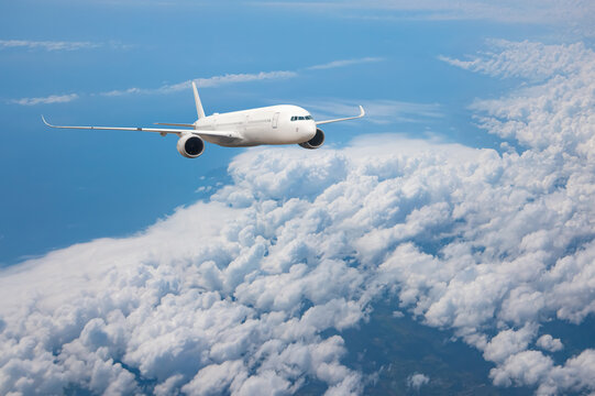 White passenger airplane flying in the sky amazing clouds in the background - Travel by air transport