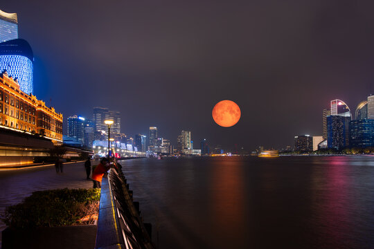 Shanghai colorful skyline with motion speed light of passing ferry in the foreground with full moon at night - Shanghai, China