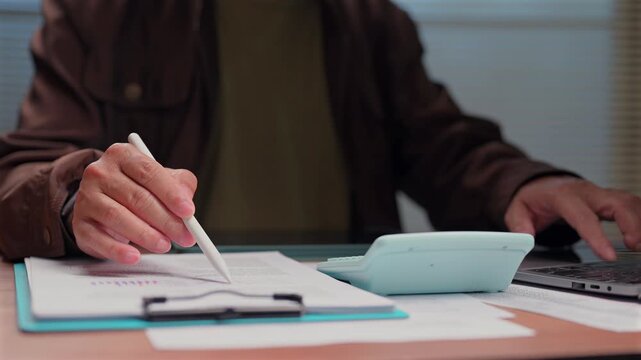 Person analyzing financial document holding stylus pen calculating budget corporate desk keyboard computer productivity management strategy expert economy business growth profit task accountant.