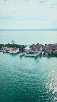 Aerial view of Sirmione Castle with surrounding lake and old town. Medieval architecture on Lake Garda