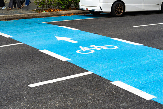 Blue bicycle lane on an asphalt city street with white road markings