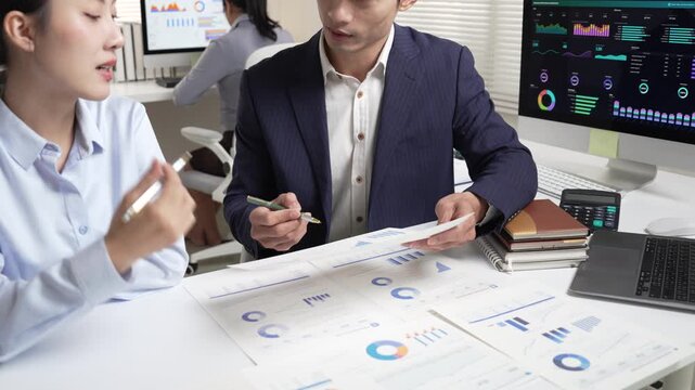 Asian business colleagues analyzing financial reports during a meeting in the office