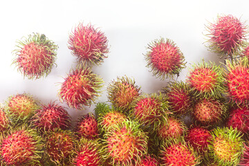 Obraz premium Fresh rambutan fruit heap on white background with copy space