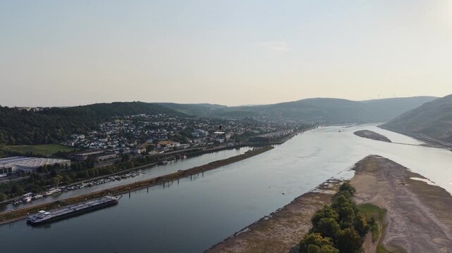Drone aerial view of Klopp Castle hill in Bingen am Rhein, Germany, featuring the forested hillside crowned by Klopp Castle, vineyards, historic architecture and the Rhine riverside below. Scenic summ