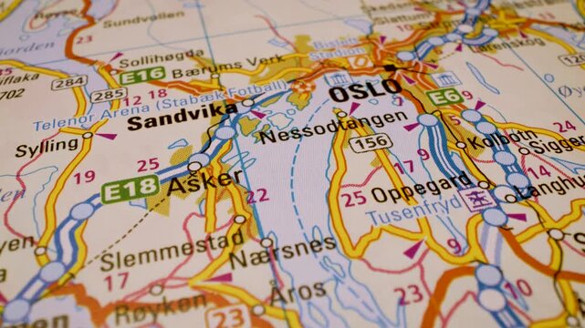 macro flight to oslo, norway, across detailed road atlas map