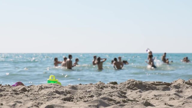 Summer Fun: Group Playing Beach Ball in Shallow Ocean Water