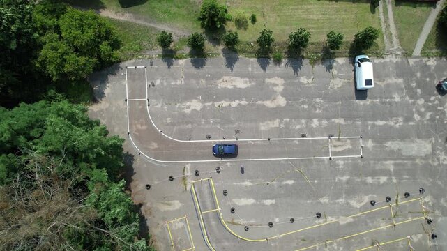 Student driver practicing reverse parking maneuver at driving school test track