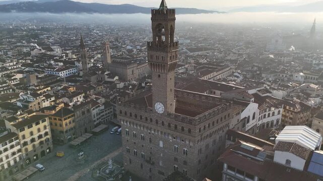 Aerial 180 degree left to right view of Palazzo Vecchio with misty morning Florence Duomo background