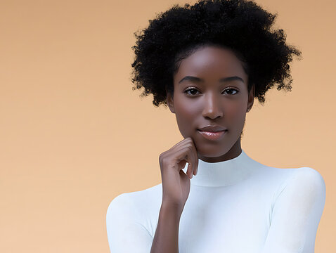 Young Black woman with natural afro hair and thoughtful expression on a plain background