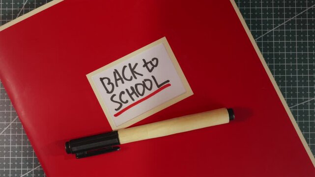 Back to School red notebook folder on wooden desktop