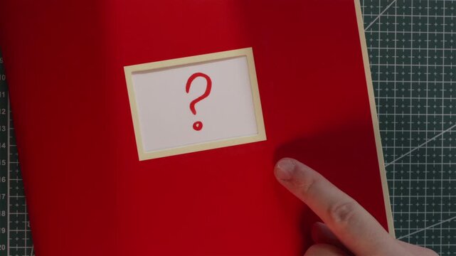 Wide view of red notebook with question mark query label