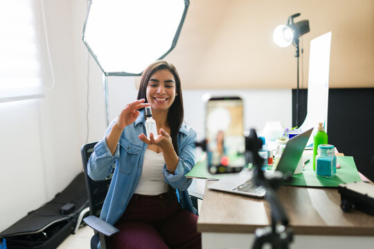 Vlogger woman creating video content, sharing product review on social media live stream using a smartphone