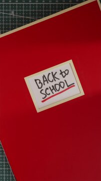 Back to School handwritten label on red notebook cover