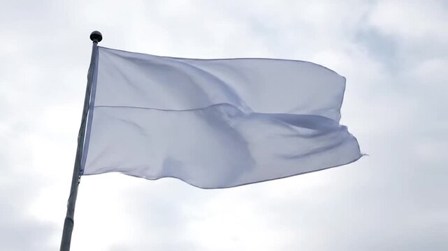 Plain White Flag Waving Gently on a Flagpole Against a Cloudy Sky, Symbolizing Peace or Surrender