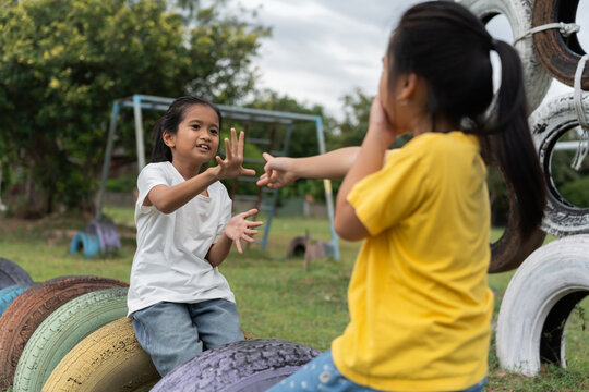 Children enjoying a rock paper scissors game on a school playground. Active outdoor play encourages communication, strategic thinking, friendship, teamwork, learning and healthy childhood development.