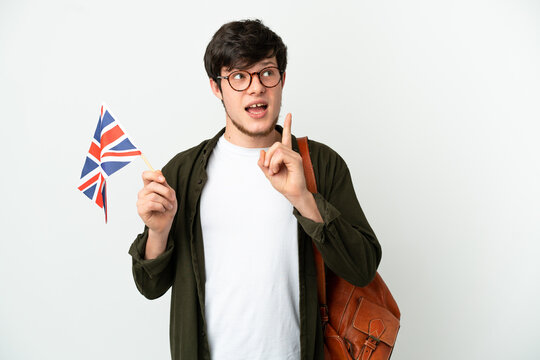 Young Russian man holding an United Kingdom flag isolated on white background thinking an idea pointing the finger up