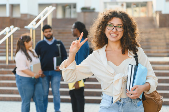 Happy diverse student showing peace sign on campus