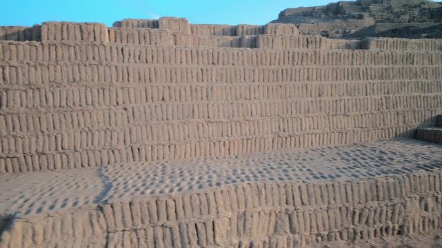 Close up sliding shot of ancient geometric adobe brick wall steps at Huaca Pucllana