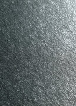 Close-up of a textured surface. the surface appears to be made of a shiny, metallic material with a dark grey color. the texture is rough and uneven, with small bumps and grooves creating a pattern.