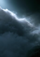 Fototapeta premium Close-up of a stormy sky. the sky is dark and cloudy, with a large cloud in the center of the image. the cloud is white and fluffy, and it appears to be moving towards the right side of the frame.