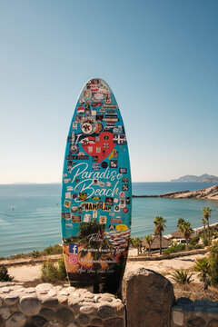 Paradise Beach, Kos, Greece - 10.09.2025: A surfboard propped up on Paradise Beach on the Greek island of Kos, with the beach in the background.