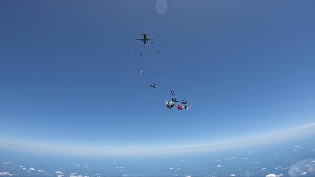 More than 100 skydivers together in a large formation.