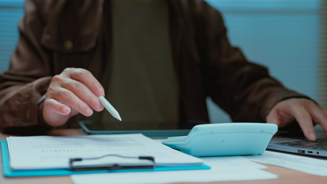 Staff check data holding device typing keyboard reviewing budget sheets planning revenue strategy managing finance audit cost profit asset market commerce business tax funds money value loan cash.