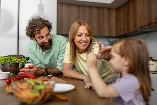 Family cooking together in a kitchen with vegetables and smiles