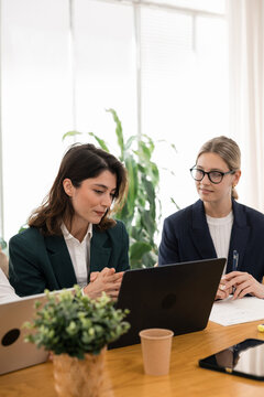 Businesswomen collaborating on laptop during office meeting