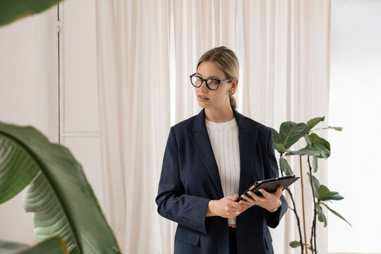 Businesswoman holding tablet working in modern office