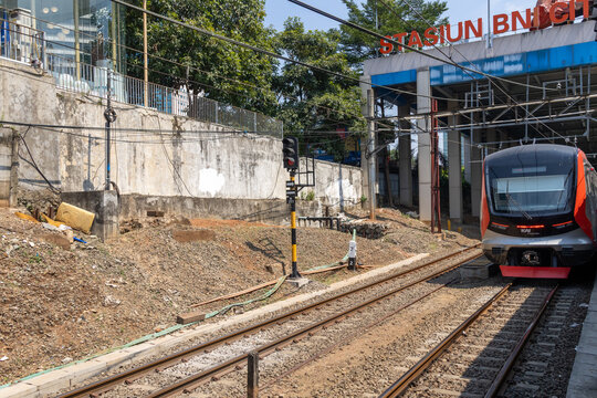 A commuter train passes through BNI City Station in Jakarta