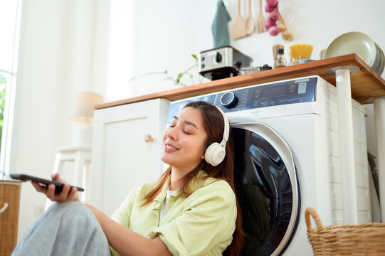 woman Listening to Music While Doing Laundry at Home in the Morning