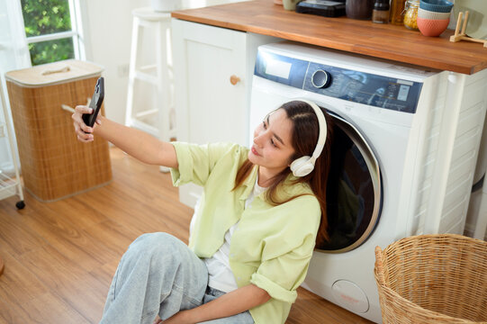 woman Listening to Music While Doing Laundry at Home in the Morning