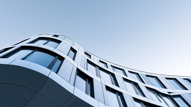 Modern curved building exterior with reflective glass windows and sleek design architecture