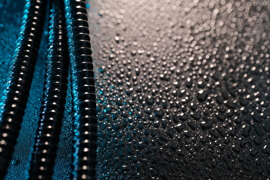 Threaded steel rods with water droplets on dark industrial background