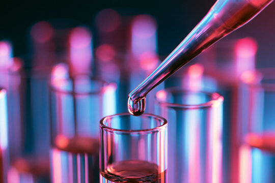 Close Up of Pipette Dispensing Liquid into Laboratory Test Tube with Neon Lighting