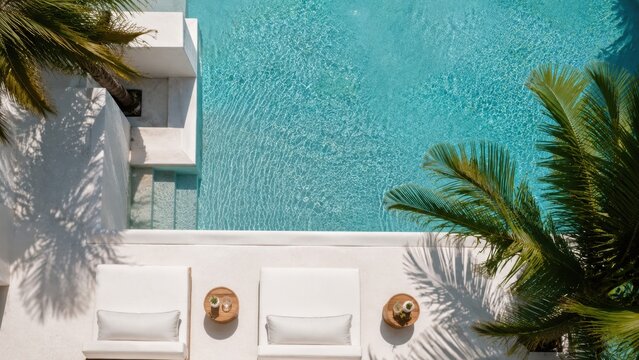 Modern White Poolside Lounge Chairs Beside Crystal Clear Tropical Swimming Pool