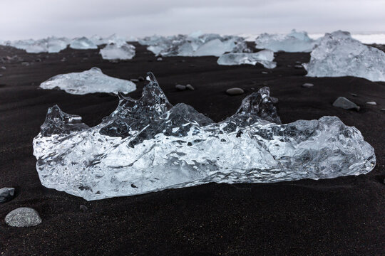 Diamond Beach Jokulsarlon transparent ice block on black sand in Iceland