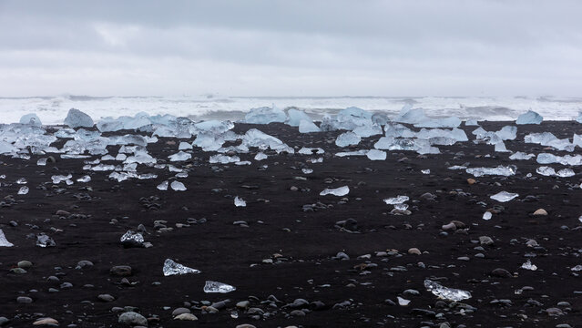 Glacial ice block cluster washed ashore on black sand at Diamond Beach, Iceland