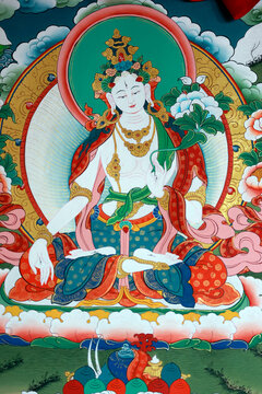 Tibetan Buddhism: a thangka of White Tara (Sitatara), the deity of compassion and longevity, with seven eyes and the varada gesture, surrounded by auspicious clouds...