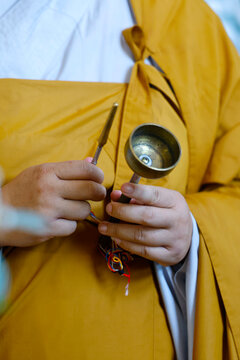 Tu An Pagoda. A monk holds the ghanta, its clapper adorned with colorful threads&mdash;an instrument used to provide a rhythmic accompaniment to the chants and recitations during ceremonies.