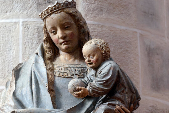 Notre-Dame Collegiate Church. Polychrome statue of the crowned Virgin Mary holding the Child, who is holding a globe.
