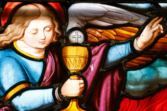 Notre-Dame Collegiate Church. Stained-glass window depicting an angel holding a sacred chalice with a host and a cross. Eucharistic celebration.