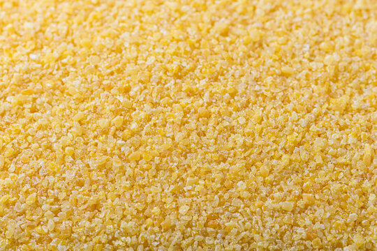 Close up top view texture background of raw yellow corn grits